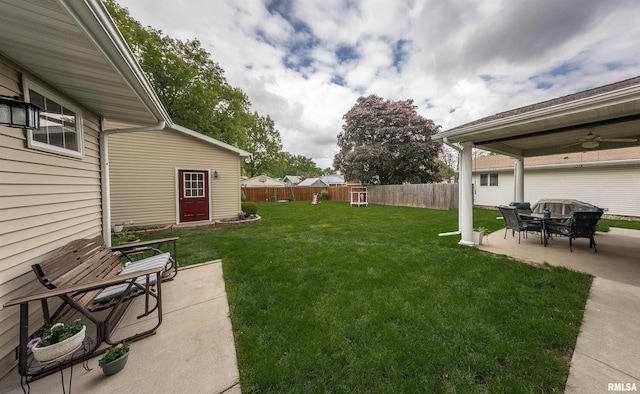 view of yard featuring a fenced backyard, a patio, and a ceiling fan