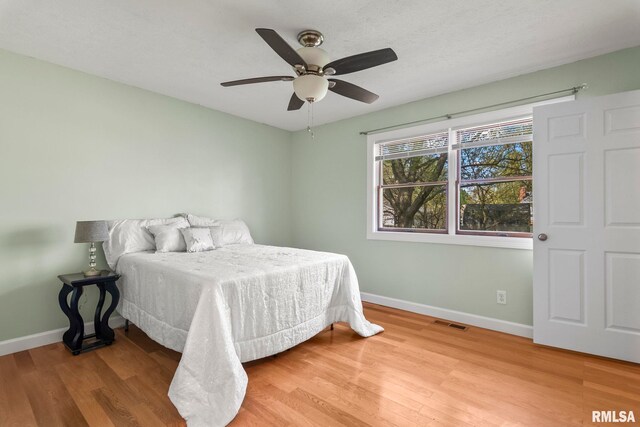 bedroom with visible vents, wood finished floors, and baseboards