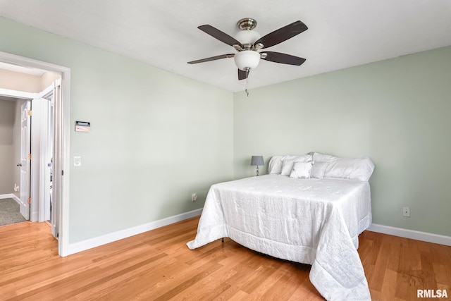 bedroom with baseboards, wood finished floors, and a ceiling fan