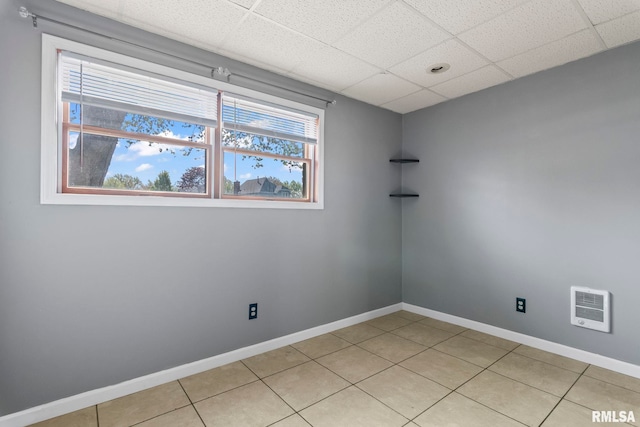 spare room with light tile patterned floors, a paneled ceiling, visible vents, and baseboards