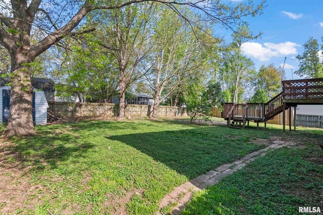 view of yard with a wooden deck, stairway, and a fenced backyard