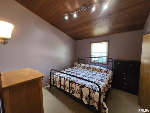 bedroom featuring vaulted ceiling, light carpet, and wood ceiling