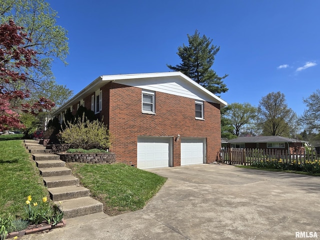 view of side of property featuring brick siding, fence, driveway, and an attached garage