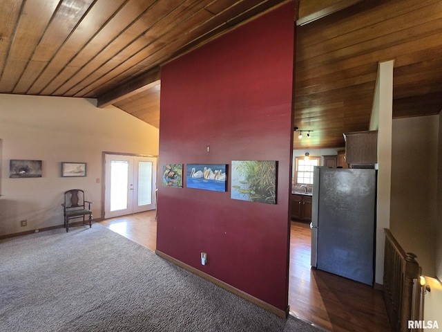 hallway featuring wooden ceiling, lofted ceiling with beams, carpet, baseboards, and french doors