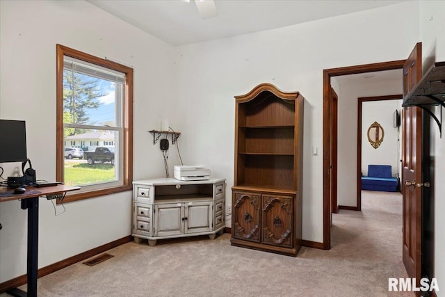 home office with visible vents, a wealth of natural light, and light carpet