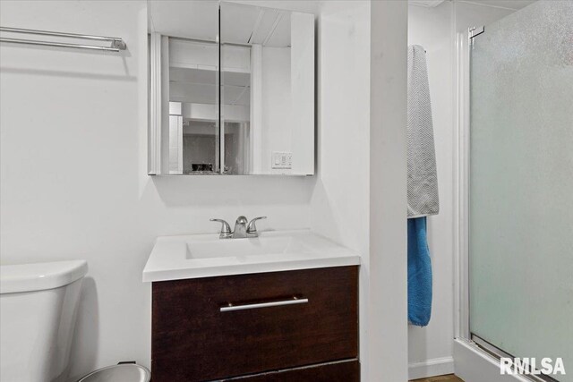 full bathroom with toilet, a shower stall, and vanity