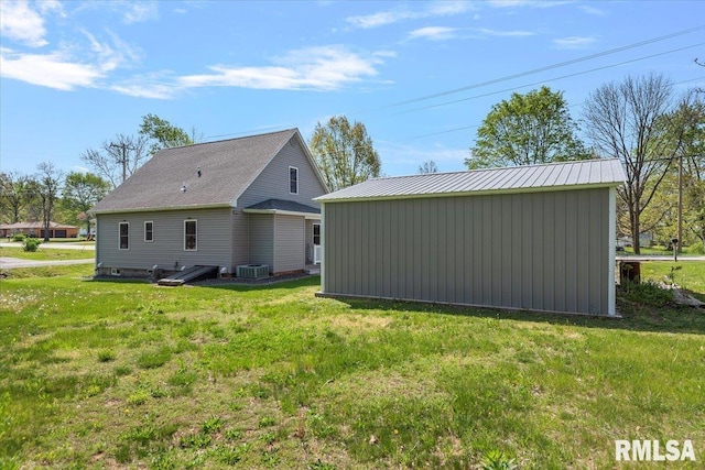 back of house with an outdoor structure, a yard, and cooling unit