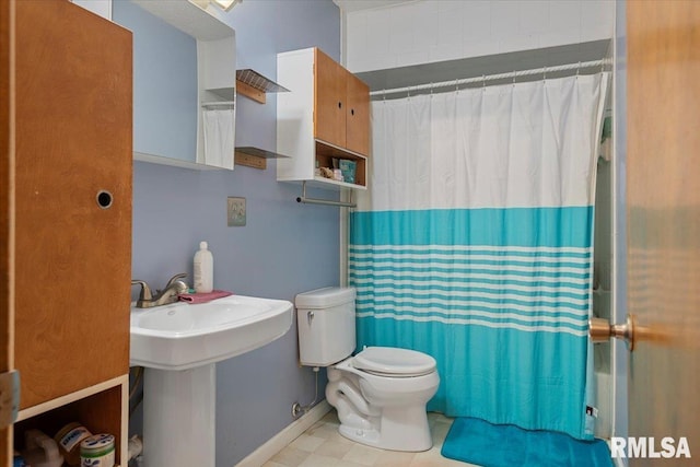 bathroom with a shower with curtain, toilet, tile patterned flooring, and baseboards