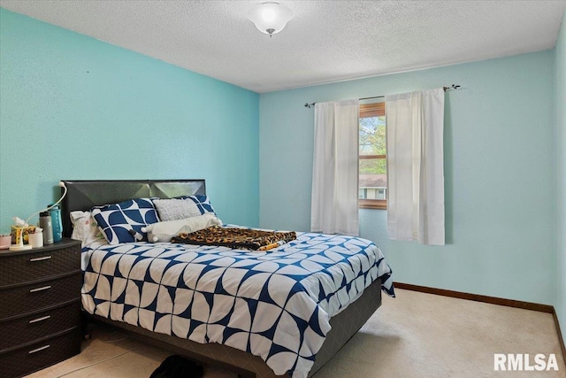 bedroom featuring baseboards, a textured ceiling, and light colored carpet