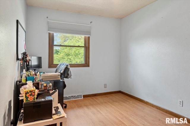 office featuring visible vents, light wood-type flooring, and baseboards