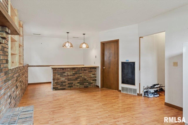 unfurnished living room with visible vents, baseboards, and light wood-type flooring