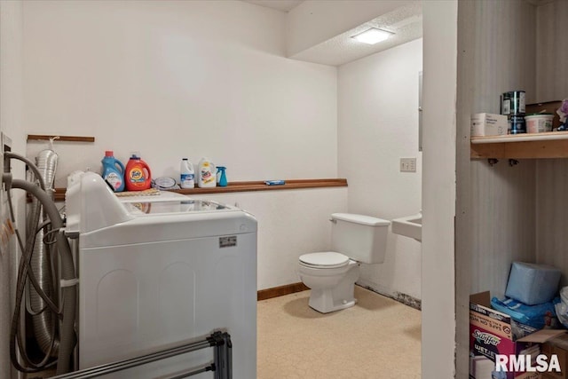 bathroom featuring separate washer and dryer and toilet