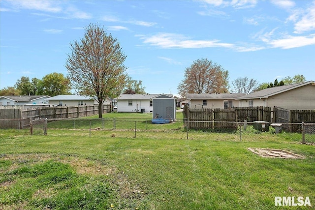 view of yard with an outbuilding, a storage shed, and a fenced backyard