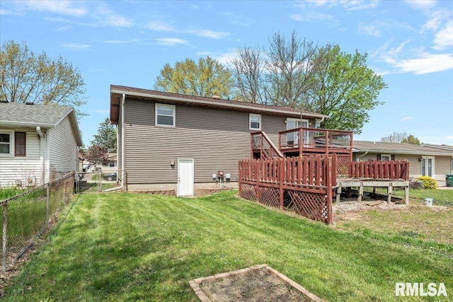 rear view of property featuring fence, a deck, and a yard