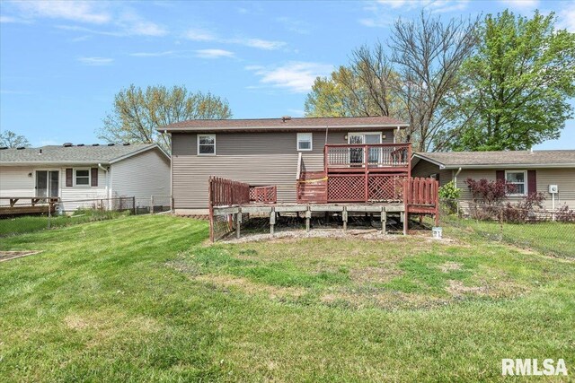 back of house featuring fence, a wooden deck, and a yard