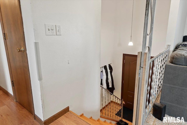 stairway with wood finished floors and baseboards