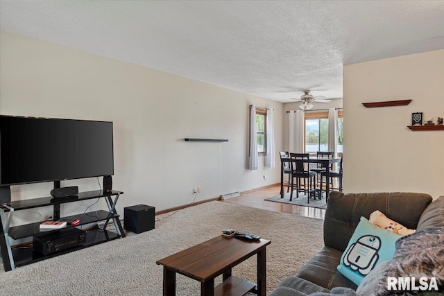 carpeted living area featuring a textured ceiling, ceiling fan, baseboards, and visible vents