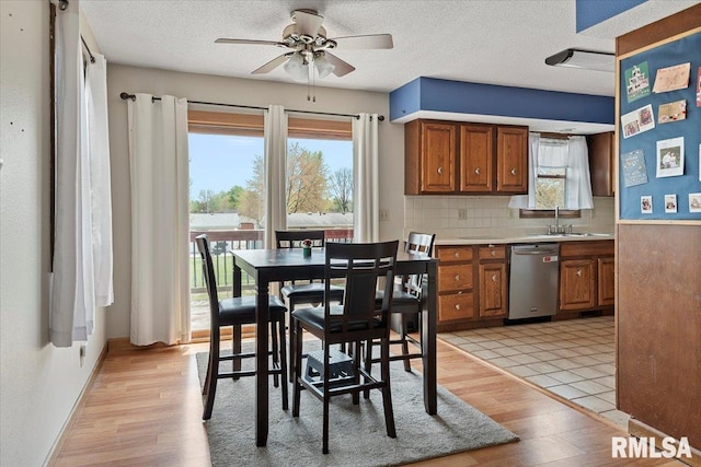 dining room with a textured ceiling, ceiling fan, and light wood-type flooring