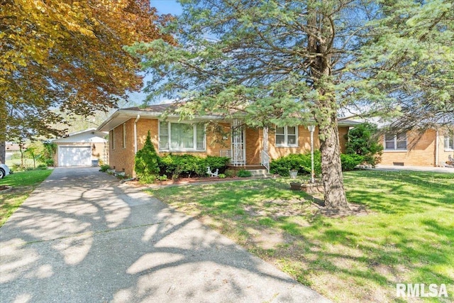 view of front of home featuring an outdoor structure, aphalt driveway, a front yard, and brick siding