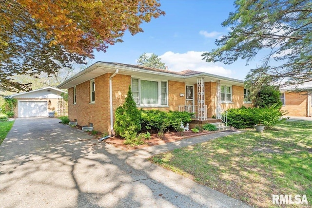 bungalow-style home with a detached garage, brick siding, an outdoor structure, and aphalt driveway