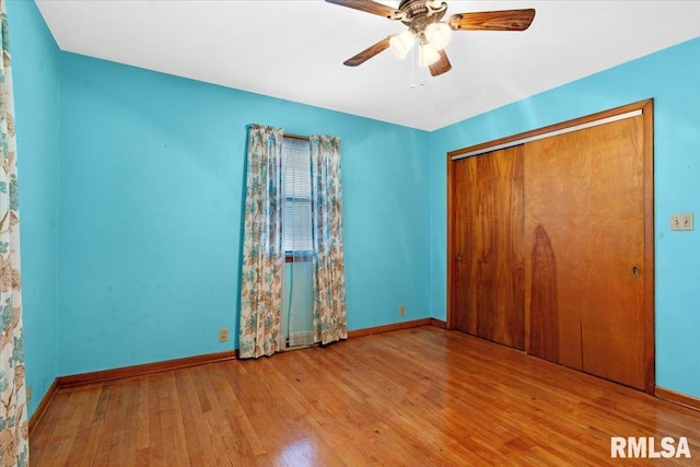 unfurnished bedroom featuring baseboards, a closet, and wood finished floors