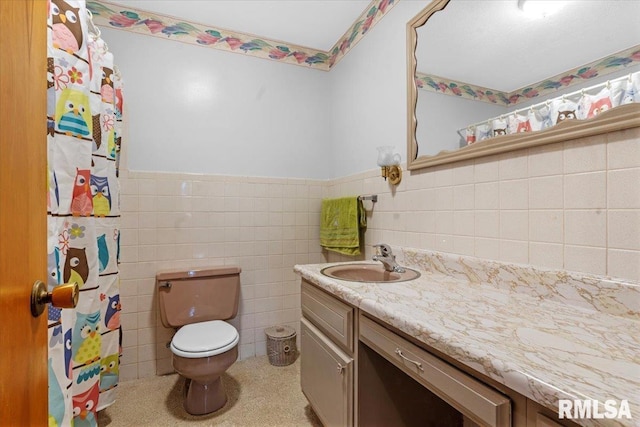 full bath featuring wainscoting, vanity, toilet, a shower with shower curtain, and tile walls
