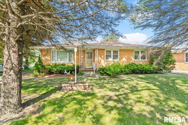 single story home with brick siding and a front yard