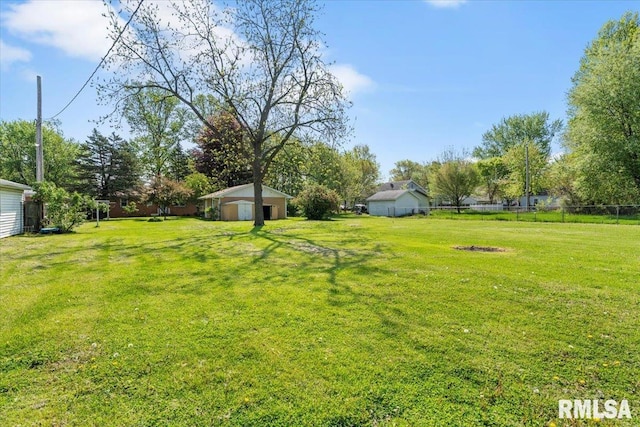 view of yard with fence and a garage
