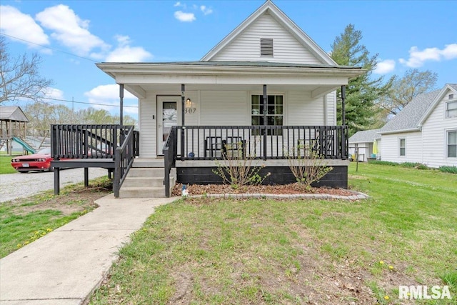 shotgun-style home featuring a porch and a front lawn