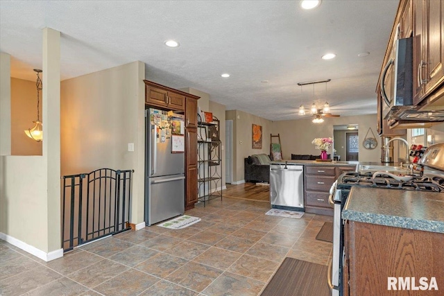 kitchen with baseboards, brown cabinetry, appliances with stainless steel finishes, and recessed lighting