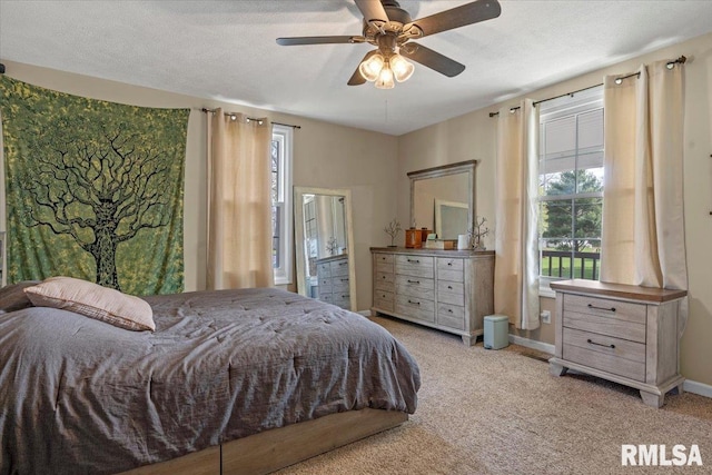bedroom featuring a ceiling fan, a textured ceiling, carpet, and baseboards