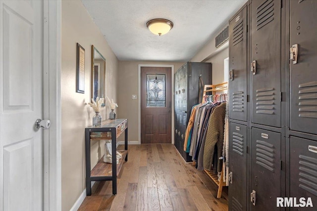 entrance foyer with baseboards, light wood-type flooring, and a textured ceiling
