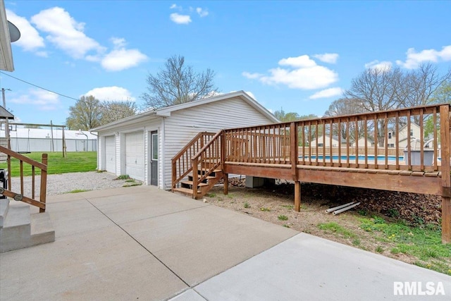 exterior space with a garage, a pool, and a wooden deck