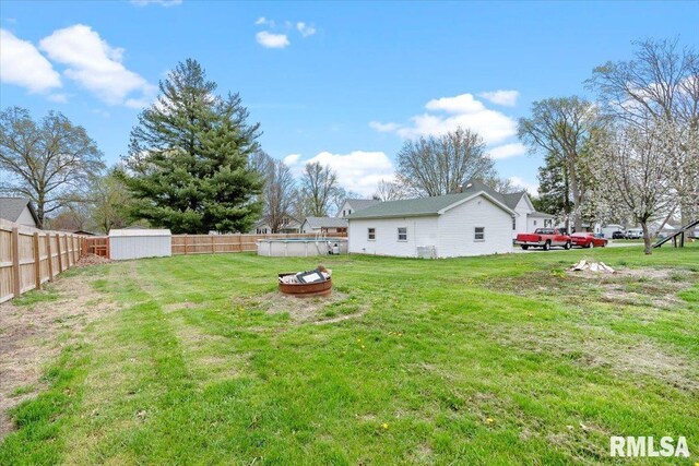 view of yard with a storage unit, fence private yard, an outbuilding, and a fenced in pool