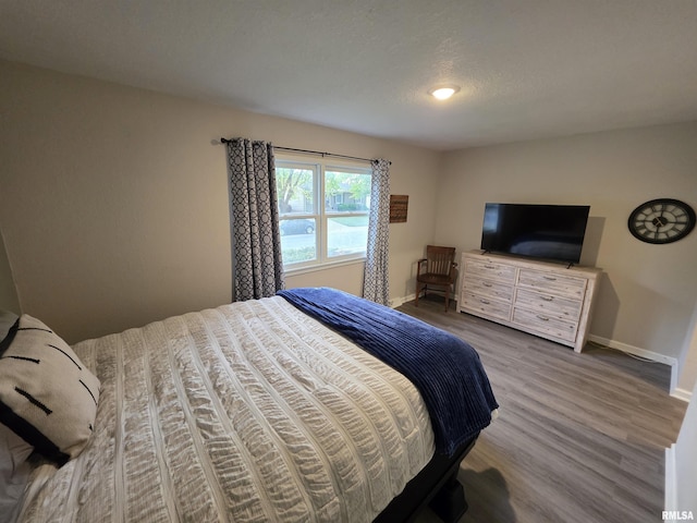 bedroom featuring wood finished floors and baseboards