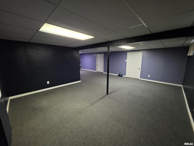 finished basement featuring a drop ceiling, carpet, and baseboards