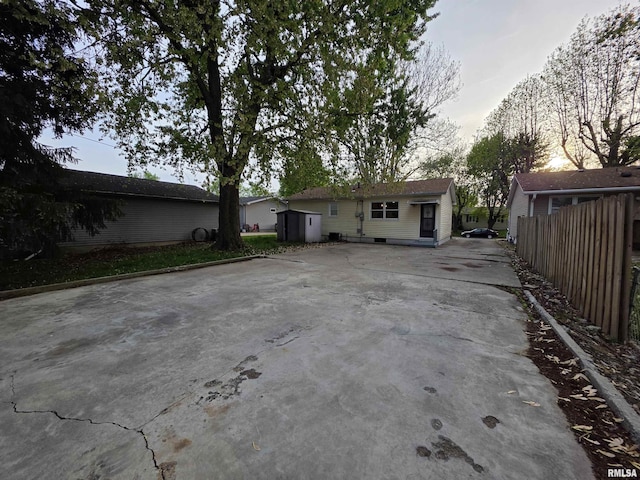 back of property featuring fence, an outdoor structure, and a shed