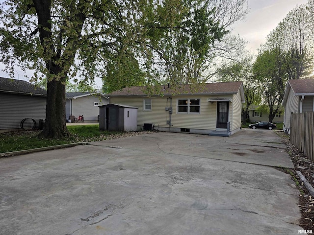back of house featuring an outbuilding, a storage shed, and fence