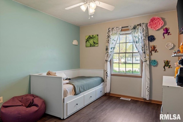 bedroom featuring baseboards, ceiling fan, wood finished floors, and visible vents