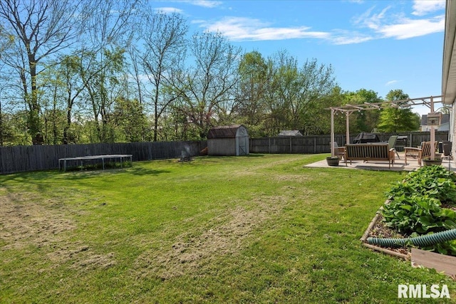 view of yard with a storage unit, a fenced backyard, and a pergola