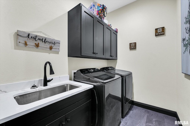 laundry area with independent washer and dryer, baseboards, cabinet space, and a sink