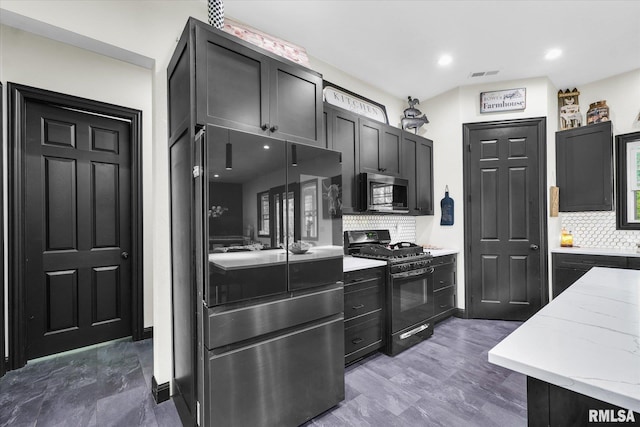 kitchen with stainless steel microwave, smart refrigerator, black range with gas stovetop, visible vents, and light stone counters