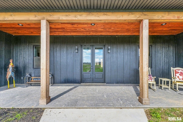 doorway to property featuring french doors, board and batten siding, and a patio area