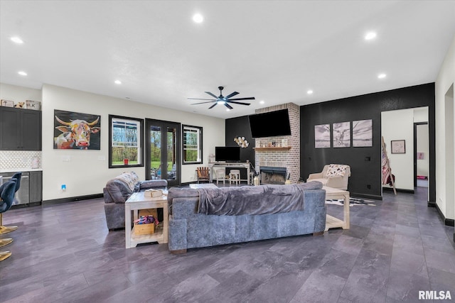 living area with a brick fireplace, recessed lighting, a ceiling fan, and baseboards