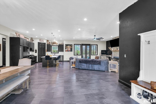living area featuring recessed lighting, ceiling fan, and a fireplace