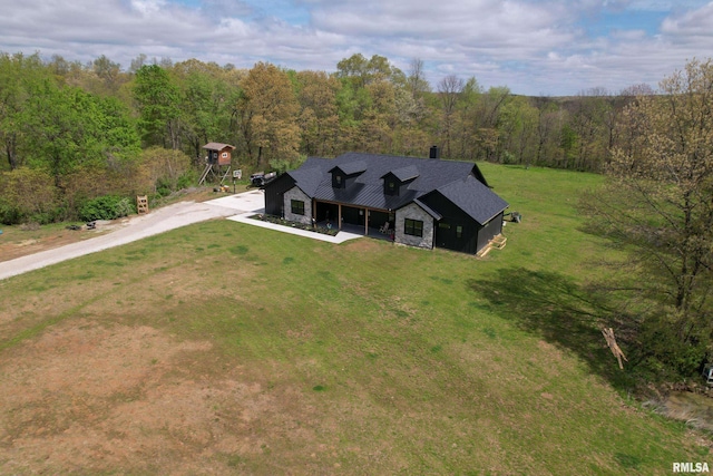 drone / aerial view featuring a wooded view