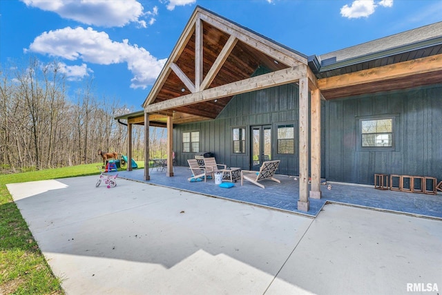 exterior space with board and batten siding and a patio area
