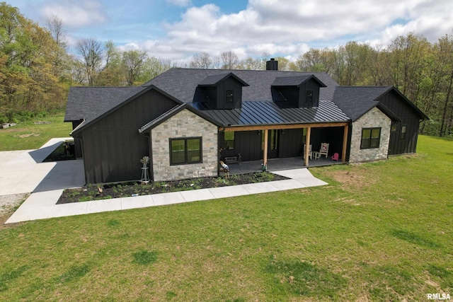 view of front of house featuring a chimney, board and batten siding, a standing seam roof, stone siding, and roof with shingles