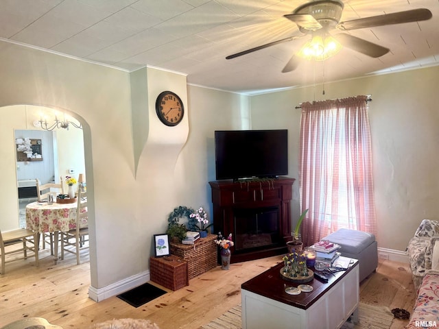 502 E Main St, Plymouth, IL 62367 - living room featuring light wood-style floors, ornamental molding, ceiling fan, a fireplace, and baseboards