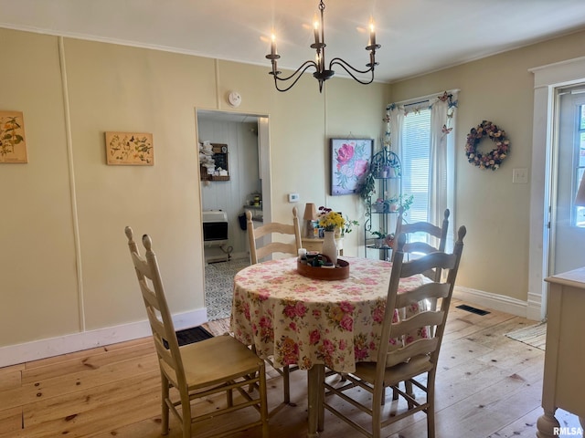 502 E Main St, Plymouth, IL 62367 - dining room featuring visible vents, light wood-type flooring, a chandelier, and baseboards